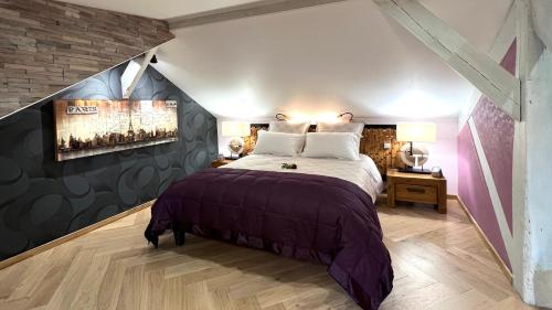 a bedroom with a large bed in a attic at Le Clos Saint Lubin in Nainville-les-Roches