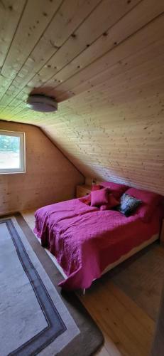 a bed in a room with a wooden ceiling at Chatka Puchatka in Gołubie