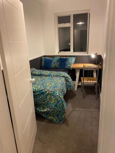 a room with a couch and a table and a window at King size room in home for couple or females in Hornchurch