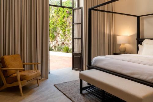 ein Schlafzimmer mit einem Bett, einem Stuhl und einem Fenster in der Unterkunft Gran Faena in Aguascalientes