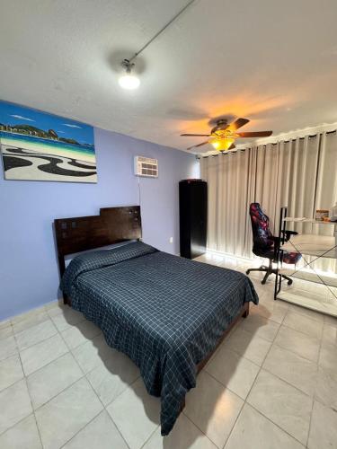 a bedroom with a bed and a table and a chair at Escape Acapulco in Acapulco