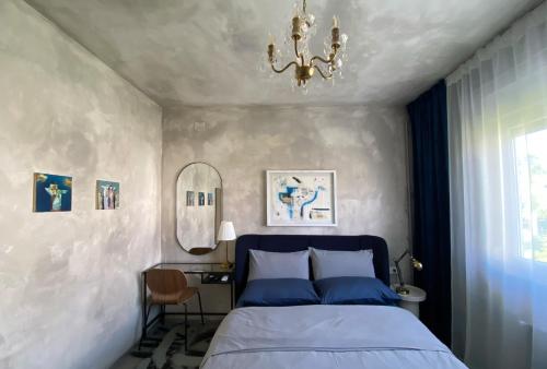 a bedroom with a blue bed and a chandelier at Ema's double bedroom in Umag