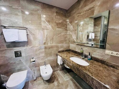 a bathroom with a sink and a toilet and a mirror at Apart Maristella sea view in Odesa