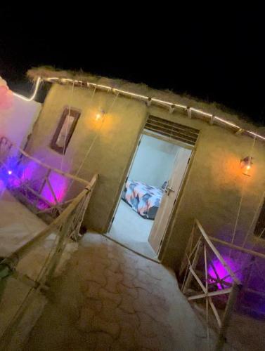 an open door of a building with purple lights at Mandys Farm House in Manjhāoli