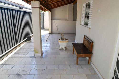 a porch with a bench and a potted plant at Casa Completa em Socorro SP - Com Piscina, Churrasqueira e Roupa de Cama in Socorro