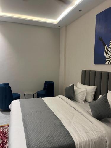 a bedroom with a large bed and two chairs at Hotel route 54 in Bathinda