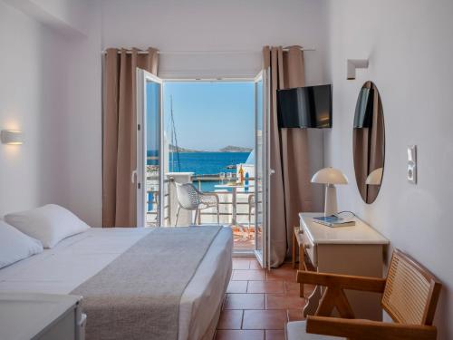 a bedroom with a bed and a view of the ocean at Galini Rooms in Naousa