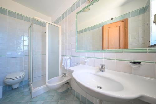 a bathroom with a sink and a toilet and a mirror at La Capannina - Hotel & Apartments in Ischia Town
