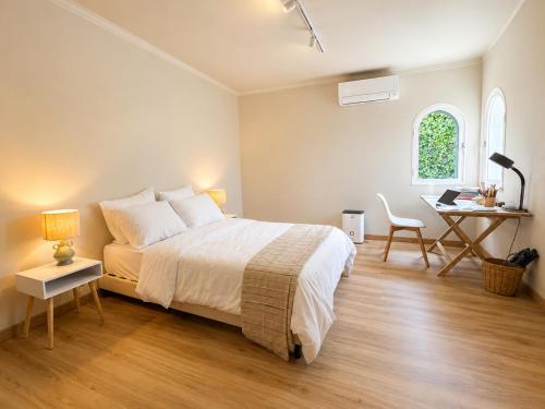 a bedroom with a bed and a table and a desk at Quinta do Carril in Reguengo