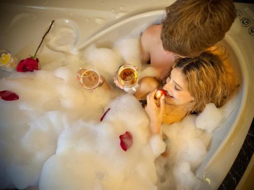 a couple laying in a bath tub with wine glasses at Quinta do Carril in Reguengo