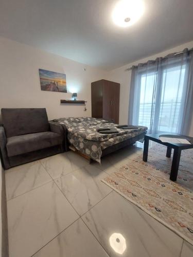 a bedroom with a bed and a couch and a table at Apartmani Vlatkovic 1 Zavojsko jezero in Pirot