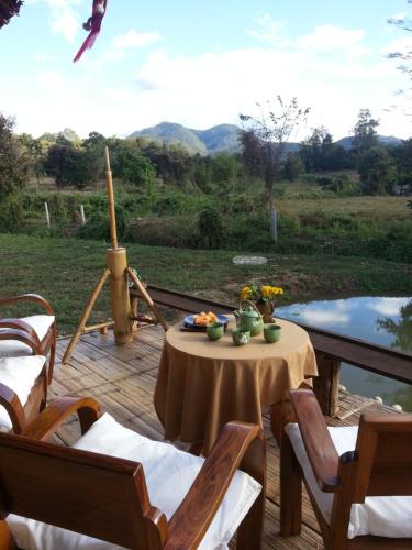 a table and chairs on a deck with a view at Tulip Resort Pai in Pai