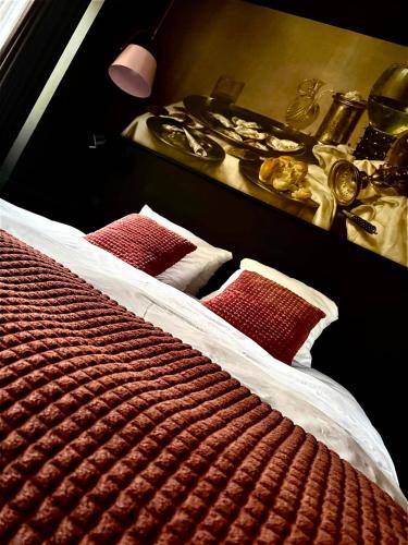 a bedroom with two beds with red pillows and a table at Hotel Pension de Tipmast in Bladel