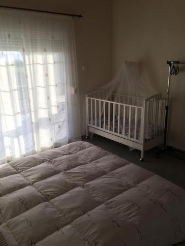 a bedroom with a large bed and a crib at Villa Archontiko in Mirodháton