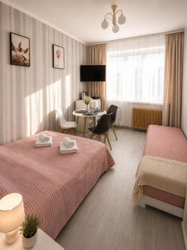 a hotel room with two beds and a table at Pokoje gościnne Moli in Łeba