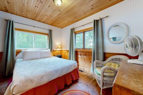 a bedroom with a bed and a chair in a room at Leavitt Bay Shores in Ossipee