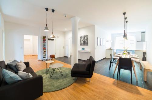 a living room with a couch and a dining room at BENSIMON apartments Mitte - Moabit in Berlin