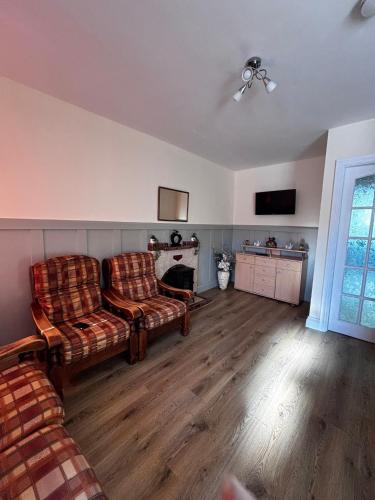 a living room with two couches and a fireplace at Old Mill Cottage in Swinford