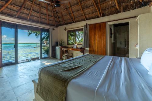 a bedroom with a bed with a view of the ocean at Yayum Bacalar in Bacalar