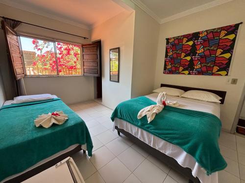 a bedroom with two beds with green sheets at Pousada Vôo da Águia in Itacaré