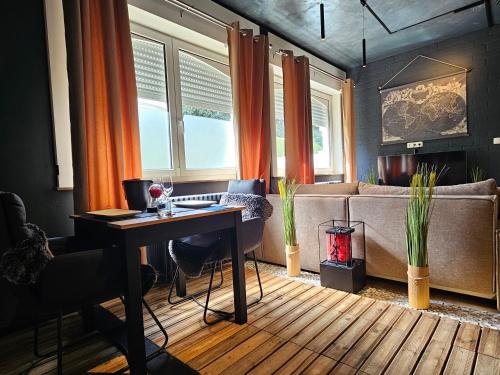 a living room with a table and a couch at L Escale Spa Privatif in Tournai