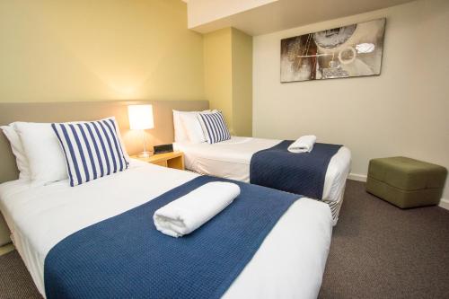 a hotel room with two beds with towels on them at Lorne Beachfront Accommodation in Lorne