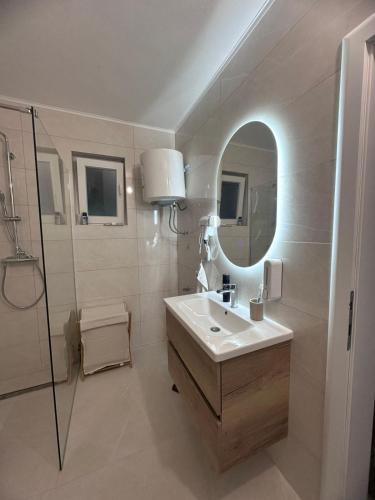 a white bathroom with a sink and a mirror at Villa Ramea in Kovačevo Polje