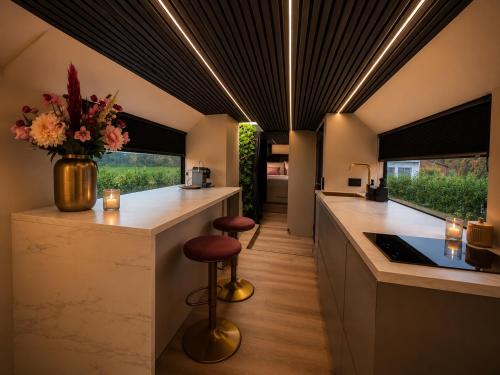 a kitchen with a counter with a vase of flowers at Bed&Bus met dakterras in Rucphen