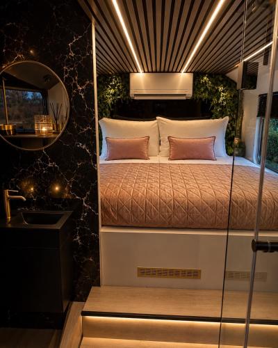 a bedroom with a bed and a mirror at Bed&Bus met dakterras in Rucphen