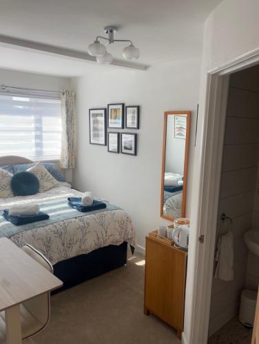 a bedroom with a bed and a mirror and a sink at Olive Mae - Cosy Room with private en-suite bathroom in Blackwood