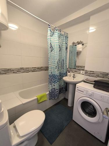 a bathroom with a toilet a sink and a washing machine at Garden City apartment Costa Adeje in Costa de Adeje