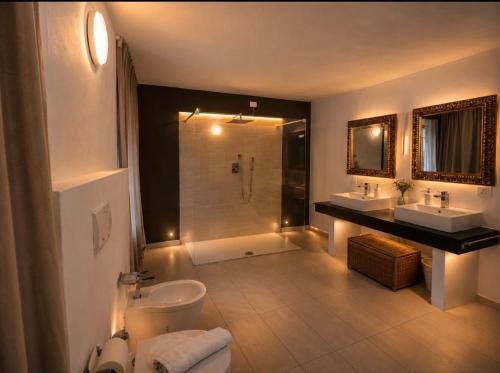 a bathroom with a toilet and two sinks and a shower at Diamante sull'acqua in Sale Marasino