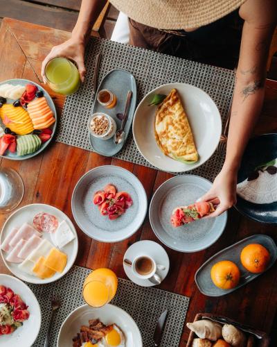 a person eating food on a table with plates of food at Insólito Boutique Hotel & Spa in Búzios