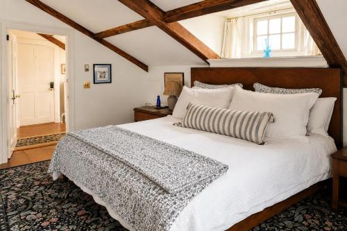 a bedroom with a large white bed with a wooden headboard at Windsor House Inn in Saint Andrews