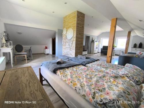 a bedroom with a large bed and a fireplace at Sielskie Markowskie in Markowskie
