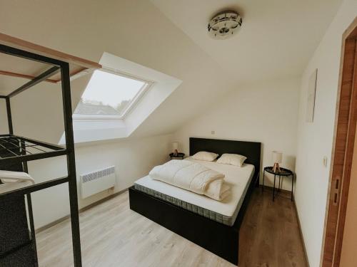 a bedroom with a bed with white sheets and a window at Chez Dubuiss in Houffalize