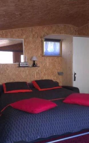 a bedroom with a large bed with red pillows at Chalet de la Grave in LʼEscarène