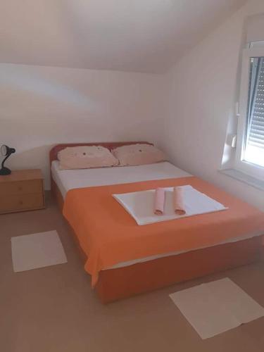 a bedroom with a bed with two towels on it at Mara apartman in Košljun