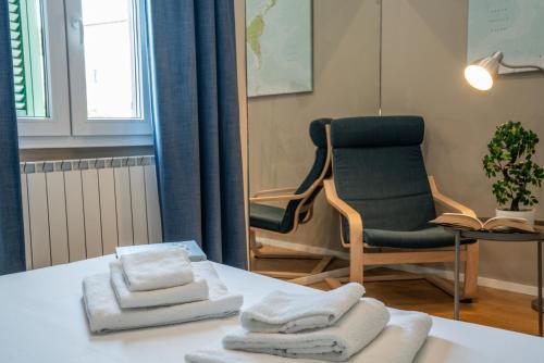a room with a chair and towels on a table at Due Strade APT - Oltrarno Collection in Florence