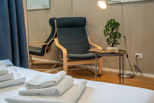 a room with a chair and a table with towels at Due Strade APT - Oltrarno Collection in Florence