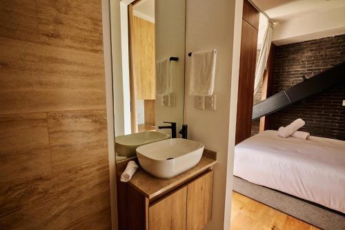 a bathroom with a sink and a bed and a mirror at Casa Colon in Mexico City