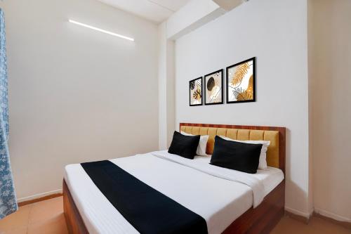 a bedroom with a bed with two pictures on the wall at Hotel O Peace Inn in Bhopal