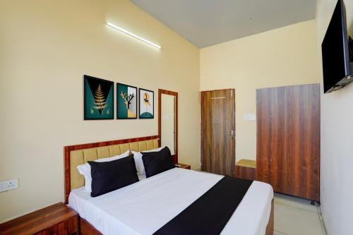 a bedroom with a bed and a television in it at Hotel O Peace Inn in Bhopal