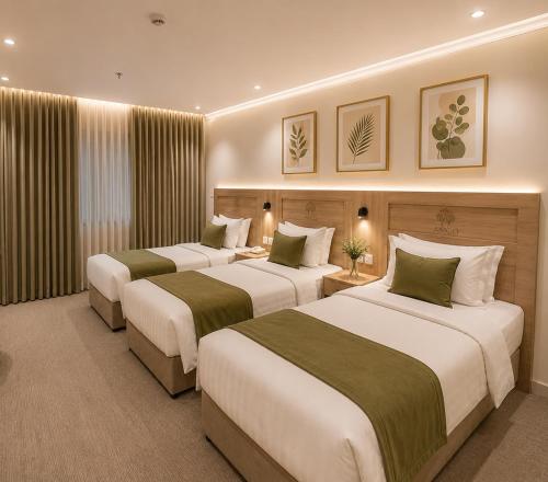 a hotel room with three beds in it at أمكو للشقق المخدومة in Jeddah