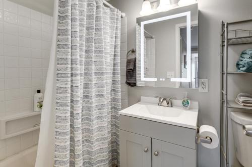 a bathroom with a sink and a shower curtain at Lake Huron Launchpad! Creekfront Condo for Two in Port Huron