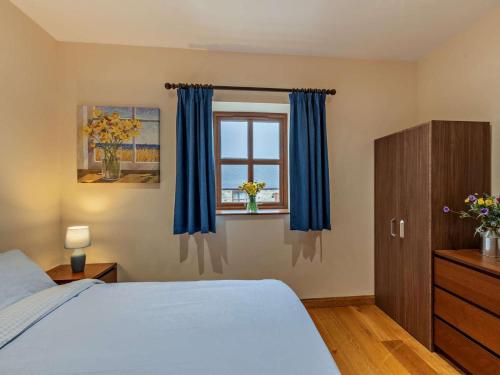 a bedroom with a bed and a window with blue curtains at 2 Bed in Bishop Auckland oc-94321 in Wolsingham