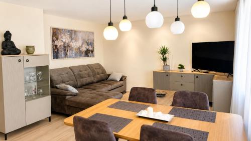 a living room with a table and a couch at Apartamentai Tarp 7 Ežerų in Zarasai