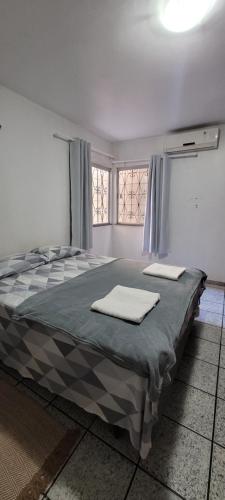 a bedroom with a bed with two towels on it at Casa grande com suite in São Luís