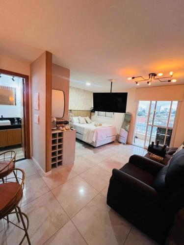 a large living room with a bed and a couch at Flat 701 in Guarulhos