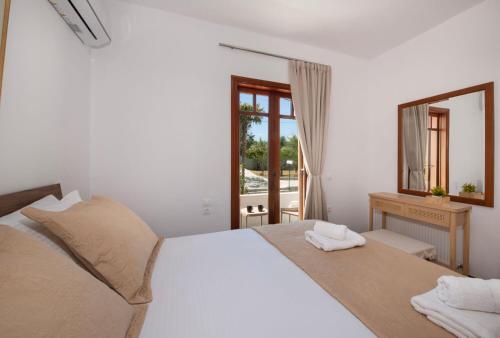 a bedroom with a white bed and a mirror at Fiore Marino in Kamisianá